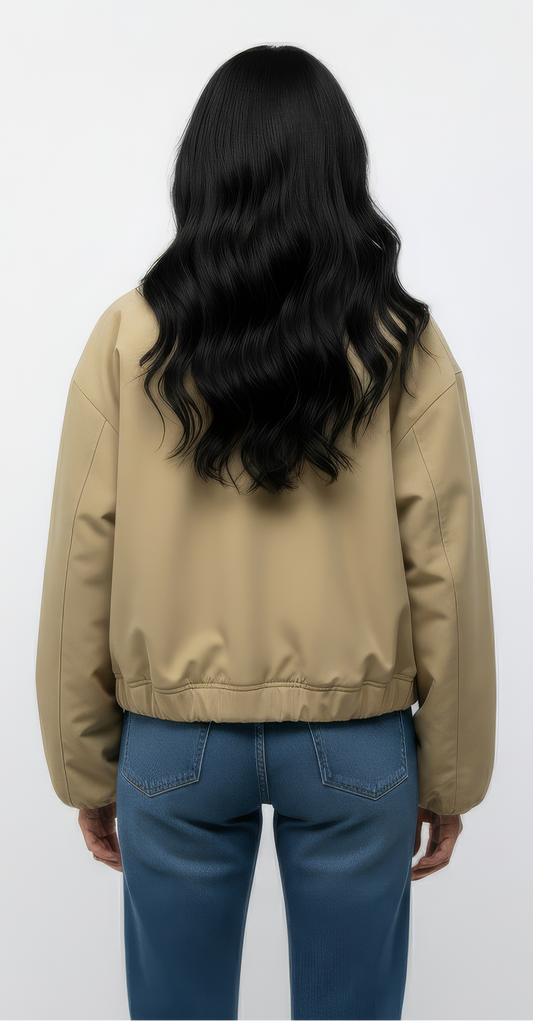 Person wearing a beige jacket and blue jeans on a white background