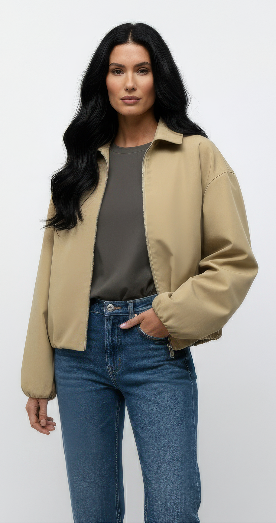 Woman wearing a beige jacket and blue jeans against a white background