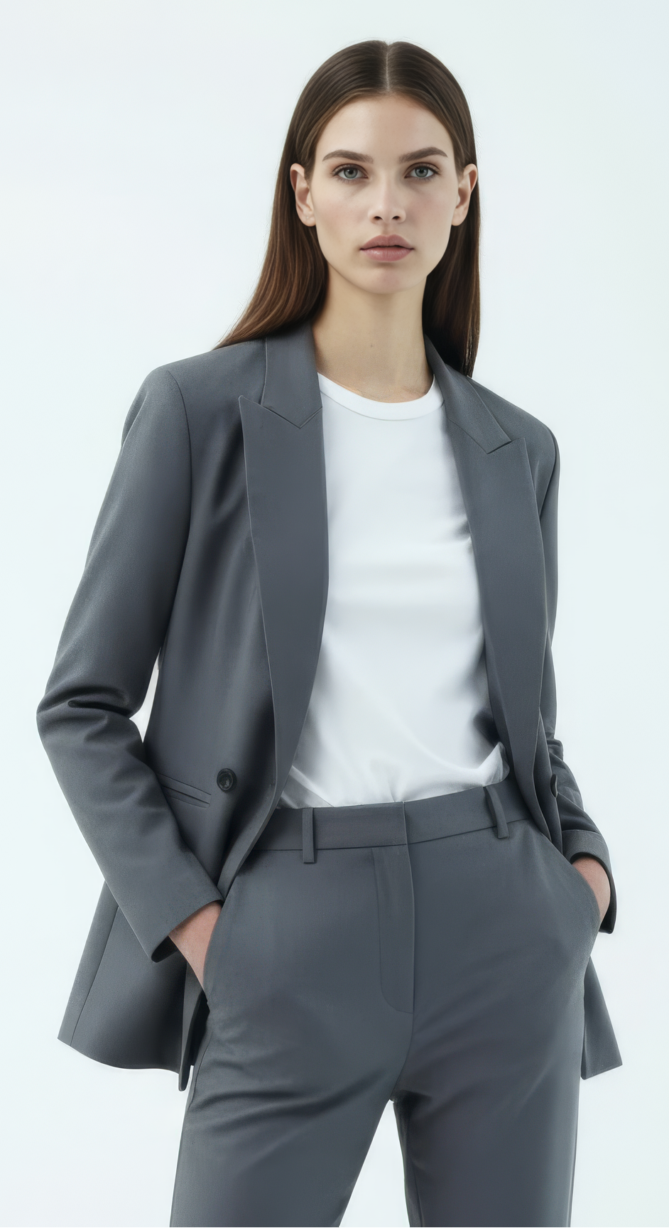 Woman wearing a gray suit with a white shirt on a light gray background